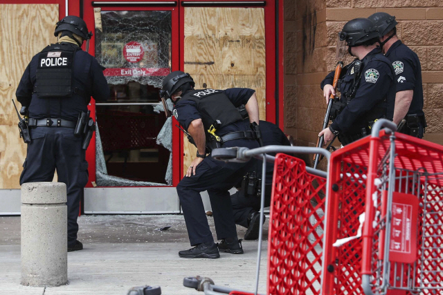 지난달 31일(현지시간) 미국 텍사스주 오스틴에서 경찰관이 폭력 시위로 인해 깨진 소매점 타겟의 유리를 점검하고 있다. /AP연합뉴스