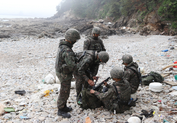 지난달 25일 충남 태안군 소원면 의항리 해변에서 경계 근무를 하던 군인들이 철수 준비를 하고 있다. 이들은 지난 23일 이곳에서 중국인들이 몰래 타고 온 것으로 추정되는 소형 보트가 발견되자 경계 근무를 해왔다.   /태안=연합뉴스