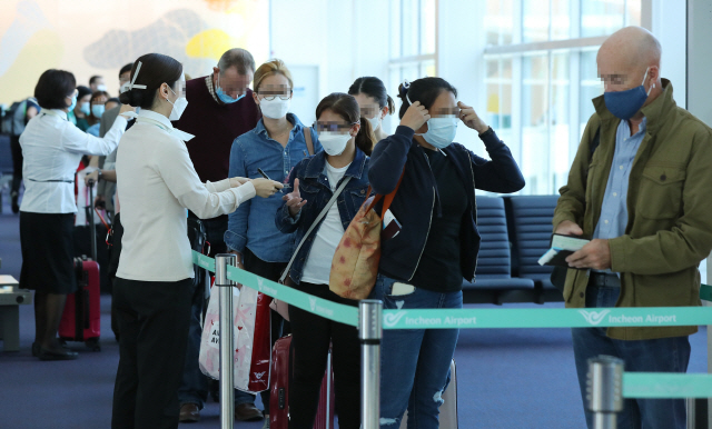 지난달 27일 인천국제공항에서 탑승객들이 마스크를 착용한 채 탑승 수속을 밟고 있다. /연합뉴스