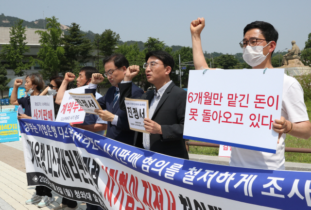 기업은행 디스커버리펀드 손실 고객과 관계자들이 8일 서울 청와대 분수대광장에서 디스커버리펀드 판매 과정에서의 불법 사례 등에 대한 조사를 요구하는 진정서를 청와대에 전달하기에 앞서 기자회견을 하고 있다. /연합뉴스