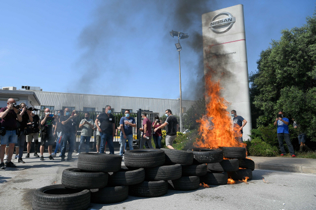 일본 닛산자동차의 스페인 바르셀로나 공장 직원들이 공장 앞에서 공장 폐쇄 결정에 항의하는 시위를 벌이며 타이어를 불태우고 있다./AFP연합뉴스