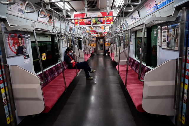 일본 시부야역에서 정차한 지하철에 마스크를 쓴 시민 한명만이 자리에 앉아있다./AFP연합뉴스