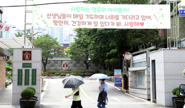 서울시교육청이 대원·영훈국제중에 대해 특성화중학교 지정을 취소하고 일반중학교로 전환하기로 결정한 10일 시민들이 강북구 영훈국제중 정문 앞을 지나고 있다.      /연합뉴스