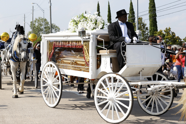 정의 일깨우고 잠들다  미국 백인 경찰의 가혹행위로 숨진 흑인 남성 조지 플로이드의 관이 9일(현지시간) 텍사스주 펄랜드의 휴스턴 메모리얼가든스 묘지로 향하는 동안 시민들이 운구행렬을 지켜보고 있다./EPA연합뉴스