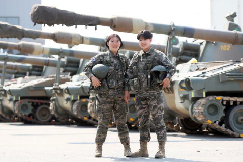 해병대 여군 최초로 K-55 자주포 조종면허를 취득한 김안나(왼쪽) 하사와 김민교 하사가 K-55 자주포 앞에서 포즈를 취하고 있다.   사진제공=국방일보