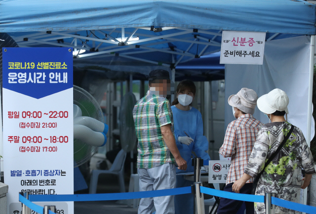 12일 오후 서울 서초구보건소에 마련된 선별진료소에서 시민들이 신종 코로나바이러스 감염증(코로나19) 검사를 받기 위해 줄을 서고 있다. /연합뉴스