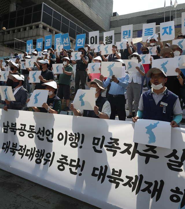 13일 서울 광화문 세종문화회관 계단에서 민주노총과 한국노총 조합원들이 남북공동선언 이행, 대북제제 해제 등의 구호를 외치고 있다. /연합뉴스