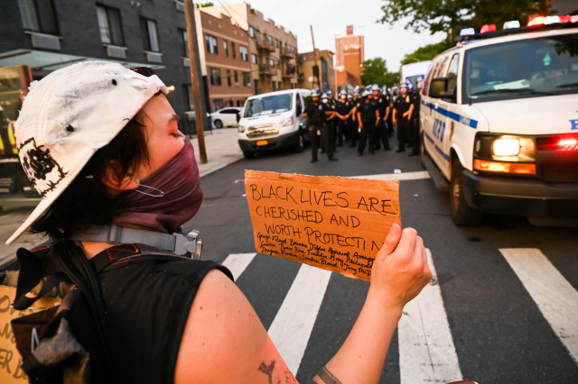 11일(현지시간) 미국 뉴욕에서 한 시위자가 팻말을 들고 인종차별 반대시위에 참여하고 있다./로이터연합뉴스