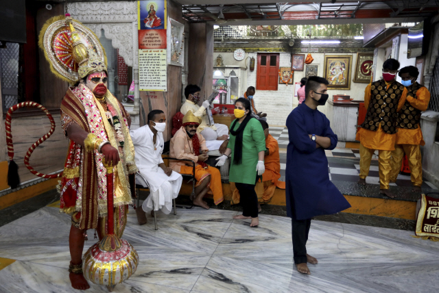 8일(현지시간) 인도 뉴델리의 힌두사원 앞에서 마스크를 쓴 한 시민이 서있다./AP연합뉴스