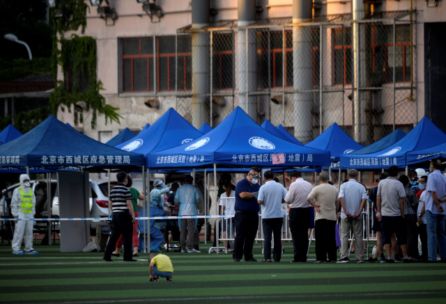 최근 중국 베이징의 최대 농수산물 시장인 신파디 도매시장을 중심으로 코로나19 확진자가 대거 발생한 가운데 신파디 시장을 방문했거나 인근에 사는 주민들이 14일 베이징의 한 스포츠센터에서 코로나19 핵산검사를 받기 위해 길게 줄을 서 있다./AFP연합뉴스