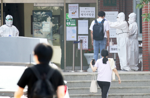 13일 경기도 수원시의 한 시험장에서 수험생들이 입장 전 체온 측정과 손 소독을 하고 있다./연합뉴스