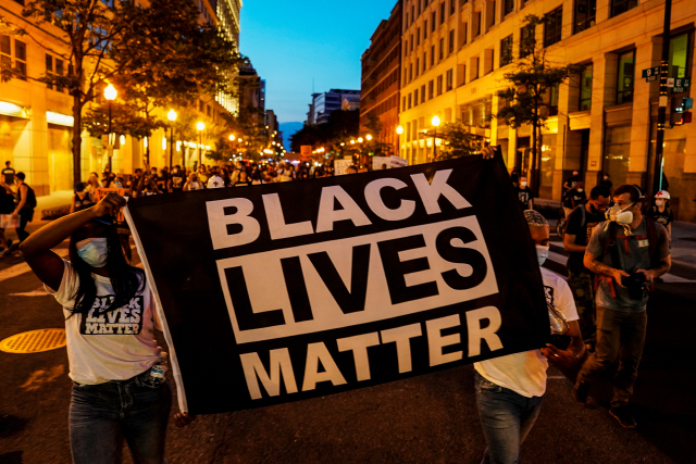 14일(현지시간) 미국 워싱턴에서 시위대가 ‘흑인의 생명도 중요하다’고 적힌 현수막을 들고 인종차별 반대 시위를 벌이고 있다. /로이터연합뉴스