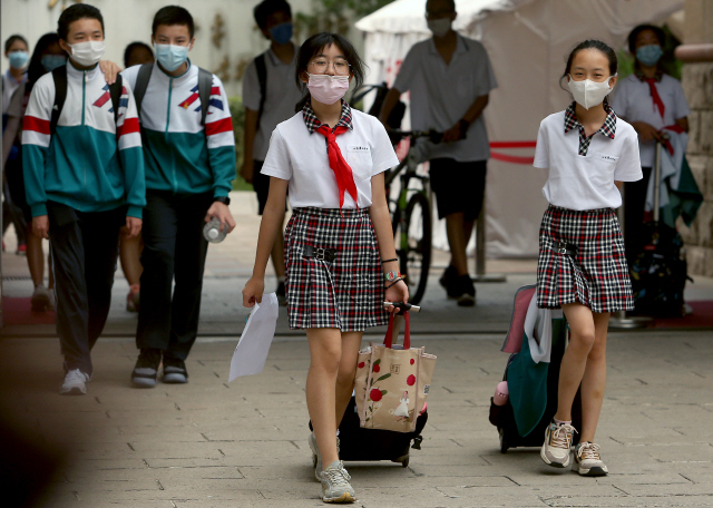15일 중국 베이징 시내 학생들이 마스크를 착용한 채로 등교하고 있다. /UPI연합뉴스