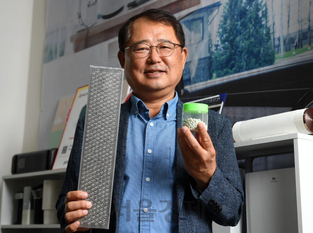 김승진 에이피씨테크 대표가 축광성 광촉매를 구성하는 비드(오른쪽)와 그것이 촘촘히 박힌 패널을 들어 보이고 있다.