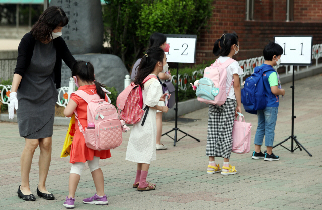 지난 11일 오전 경기도 부천시 송내동 솔안초등학교에서 처음 입학한 학생들이 교사의 안내에 따라 잠시 대기하고 있다. /부천=연합뉴스