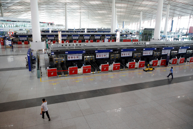 코로나19 집단감염의 영향으로 수도 베이징과 지방을 연결하는 항공편이 잇따라 취소되고 있는 가운데 17일 서우두공항의 체크인 카운트가 텅 비어 있다. /로이터연합뉴스