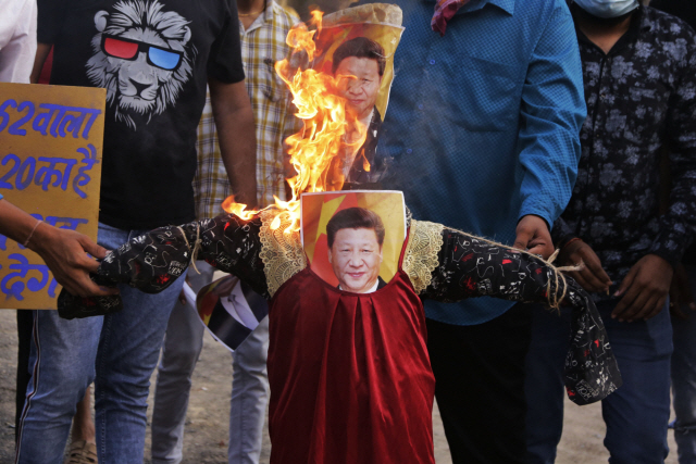 인도의 반중 시위대가 18일(현지시간) 서부 구자라트 주 최대의 도시인 아메다바드에서 시진핑 중국 주석의 꼭두각시와 사진을 불태우고 있다. 중국과 국경 무력 충돌로 인해 인도 내 반중 정서가 확산하고 있다./AP연합뉴스