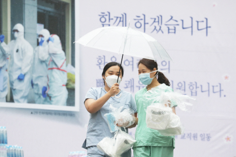 신종 코로나바이러스 감염증(코로나19) 지역거점병원인 계명대학교 대구동산병원에서 간호사들이 우산을 쓰고 보호구 착의실로 향하고 있다. /연합뉴스