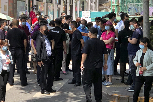 중국 수도 베이징의 한 스포츠 센터에 설치된 신종 코로나바이러스 감염증(코로나19) 검사소에서 공안과 보안요원의 통제 속에 시민들이 검사 차례를 기다리고 있다./AP연합뉴스
