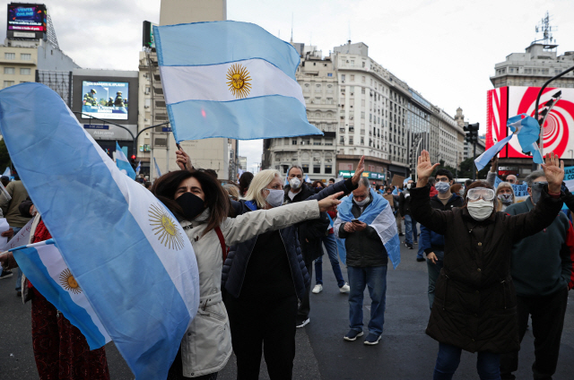 지난 8일(현지시간) 아르헨티나 부에노스아이레스에서 코로나19 방역을 위한 자택대기령이 길어지자 영업에 차질이 생긴 소상공인들이 국기를 들고 한데 모여 자택대기령 완화를 요구하는 시위를 하고 있다./AFP연합뉴스