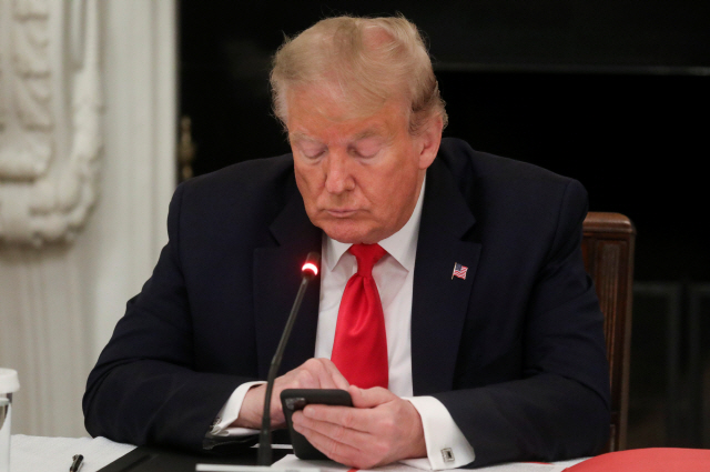 백악관에서 회의 중에 휴대폰을 지켜보고 있는 도널드 트럼프 미국 대통령. /로이터연합뉴스