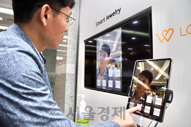 한 시민이 서울 여의도 중소기업중앙회에서 자신이 선택한 안경 제품을 실제 착용한 것처럼 보여주는 스마트서비스 체험을 하고 있다. /사진제공=중기중앙회