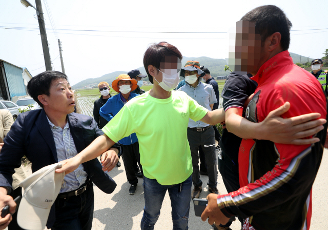 박상학 자유북한운동연합 대표(왼쪽)와 인천 강화도 주민이 지난 8일 오전 인천시 강화군 삼산면 석모리 한 해안가 진입로에서 말다툼을 벌이고 있다. 박 대표와 탈북민단체 회원들은 이날 이 지역 해안가에서 쌀을 담은 페트(PET)병을 바다에 띄워 북측에 보내는 행사를 개최하려다가 주민 반발에 부딪혀 실패하고 되돌아갔다./인천=연합뉴스