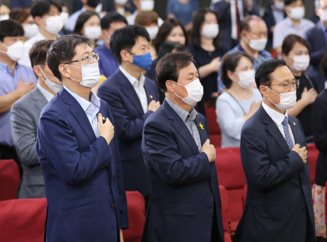 더불어민주당 김홍걸(왼쪽부터), 도종환, 홍영표 의원이 23일 오후 서울 여의도 국회 의원회관에서 열린 ‘연속토론회2 경제분야 -포스트 코로나와 대한민국 풀체인지’에 참석, 국기에 대한 경례를 하고 있다.