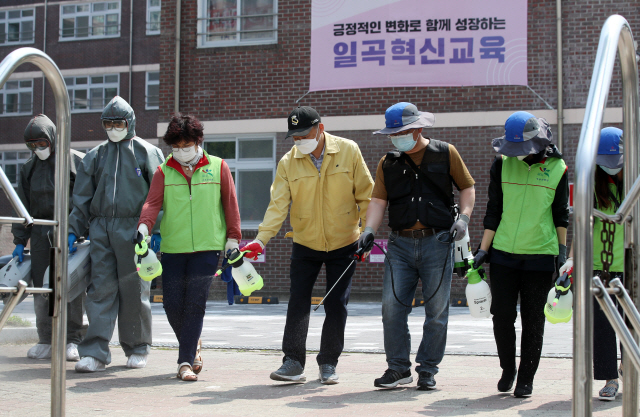 지난 22일 오전 광주 북구 일곡동의 한 학교에서 행정복지센터 방역반원과 북구보건소 직원들이 방역하고 있다. /광주=연합뉴스