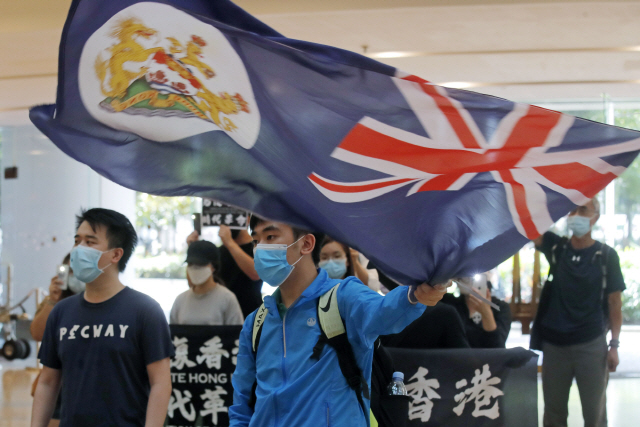 지난 12일 홍콩의 한 쇼핑몰에서 진행된 홍콩보안법 반대 시위 도중 한 시위자가 영국 식민지시절 홍콩국기를 흔들고 있다. /AP연합뉴스
