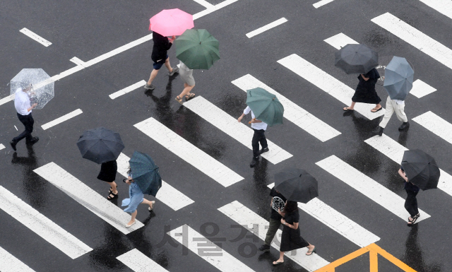 전국에 장맛비가 내린 24일 서울 광화문 인근에서 우산을 쓴 시민이 발걸음을 재촉하고 있다. 이번 비는 24일 오후부터 25일 새벽에는 남해안과 제주도, 강원 북부에 시간당 30㎜ 이상의 강한 비가 내리겠고, 전국 곳곳에 돌풍과 함께 천둥·번개가 치는 곳도 있겠다./권욱기자 2020.6.24