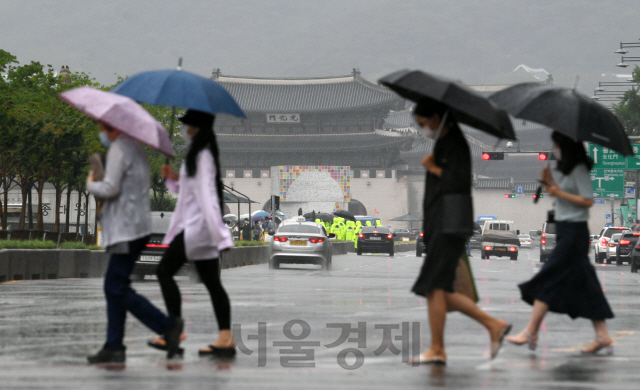 전국적으로 장맛비가 시작된 24일 서울 광화문 인근에서 우산을 쓴 시민이 발걸음을 재촉하고 있다. 이번 비는 24일 오후부터 25일 새벽에는 남해안과 제주도, 강원 북부에 시간당 30㎜ 이상의 강한 비가 내리겠고, 전국 곳곳에 돌풍과 함께 천둥·번개가 치는 곳도 있겠다./권욱기자 2020.6.24