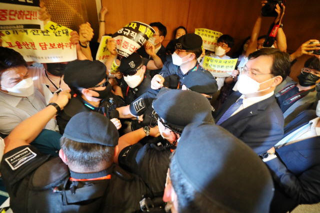 22일 인천국제공항 제1여객터미널에서 보안검색 노동자 정규직화 관련 브리핑을 마친 구본환 인천국제공항공사 사장이 브리핑실을 나와 엘리베이터로 이동하던 중 직원들의 거센 항의를 받고 있다. /연합뉴스