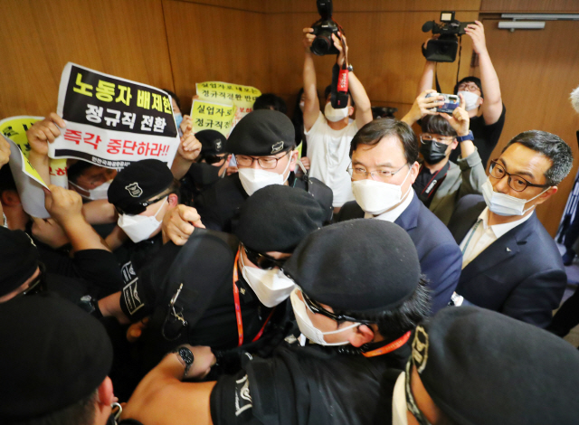 22일 인천국제공항 제1여객터미널에서 보안검색 노동자 정규직화 관련 브리핑을 마친 구본환 인천국제공항공사 사장이 브리핑실을 나와 엘리베이터로 이동하던 중 직원들의 거센 항의를 받고 있다. /연합뉴스