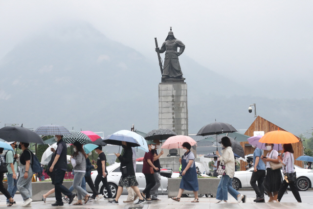 올해 장마가 시작된 가운데 우산을 쓴 시민들이 서울 세종대로 사거리를 걷고 있다./연합뉴스