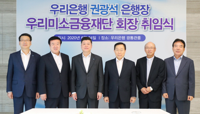 권광석(왼쪽 세번째)우리은행장이 지난 24일 우리은행 본점에서 열린 우리미소금융재단 이사회와 총회에서 신임 재단 회장에 선임돼 최홍식(왼쪽 첫번째)우리은행 개인그룹장을 비롯해 우리미소금융재단 이사들이 참석한 가운데 취임식을 갖고 있다. /사진제공=우리은행