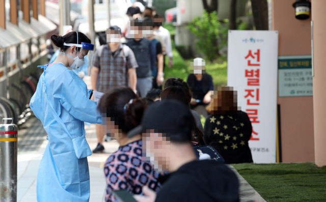 지난 5일 오후 서울 관악구보건소 앞에 마련된 신종 코로나바이러스 감염증(코로나19) 선별진료소에서 의료진들이 시민들의 진료 접수를 돕고 있다. /연합뉴스