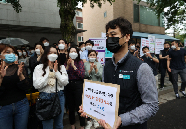 장기호 인천국제공항공사 노조위원장이 25일 오후 서울 청와대 인근에서 열린 기자회견에서 비정규직 보안검색 요원들의 정규직 전환 관련 입장을 발표한 뒤 호소문을 청와대에 전달하기 위해 이동하고 있다. /연합뉴스