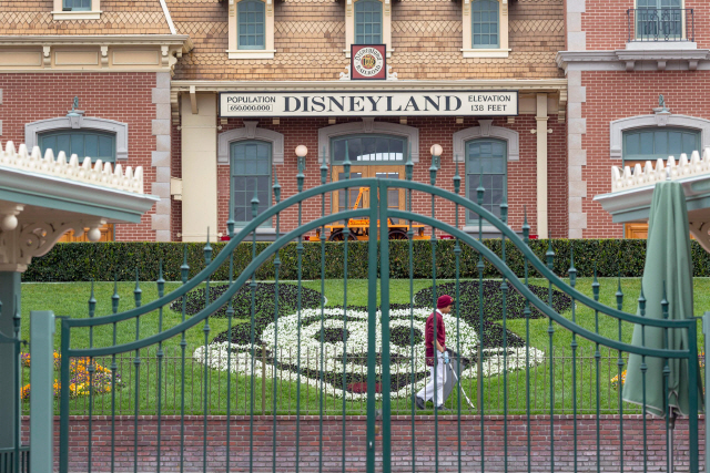 지난 3월14일(현지시간) 한 직원이 미국 캘리포니아 애너하임에서 코로나19 확산을 막기 위해 폐장한 테마파크 디즈니랜드를 청소하고 있다./AFP연합뉴스