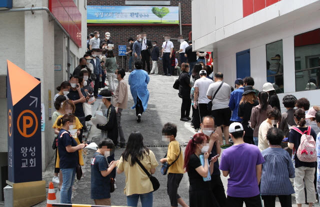 26일 신종 코로나바이러스 감염증(코로나19) 확진자가 발생한 서울 관악구 왕성교회에 설치된 임시 선별진료소에서 교인들이 검체 채취를 받기 위해 길게 줄지어 서 있다./연합뉴스