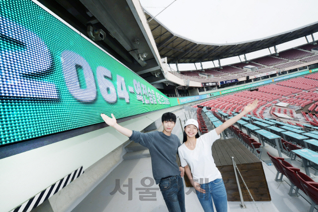 LG전자 모델이 경기도 수원KT위즈파크에서 ‘LG LED 사이니지’를 활용한 약 330m 길이의 리본보드를 소개하고 있다. 이번에 설치된 사이니지는 휘도가 6,000니트에 달해 외야 관중석에서도 각종 이벤트, 선수 소개, 응원 문구 등의 다양한 콘텐츠를 선명하게 볼 수 있다. /사진제공=LG전자