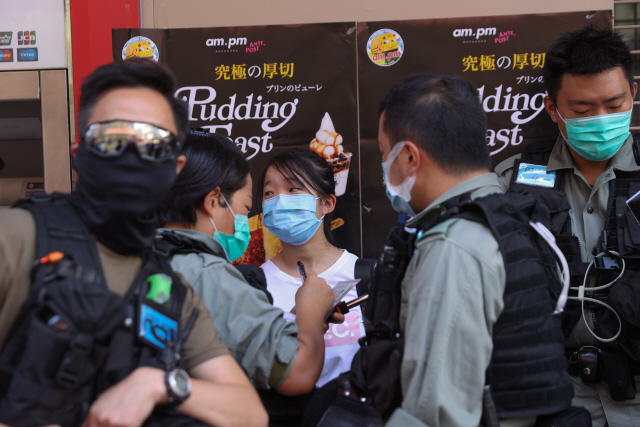 28일 홍콩에서 홍콩보안법 반대 침묵시위에 참여한 한 여성을 경찰이 포위한채 조사하고 있다. /EPA연합뉴스