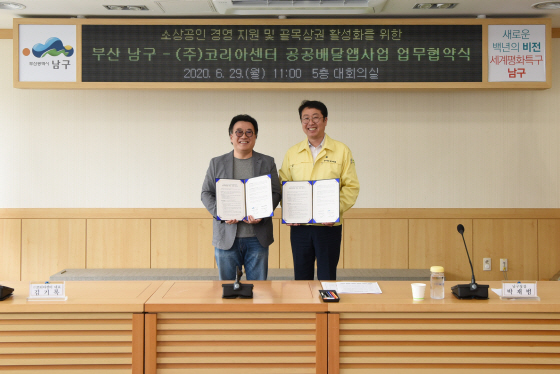 박재범(오른쪽) 부산 남구청장과 김기록 코리아센터 대표가 협약을 맺고 공공배달앱을 개발하고 운영하는 데 힘을 합치기로 했다./사진제공=남구