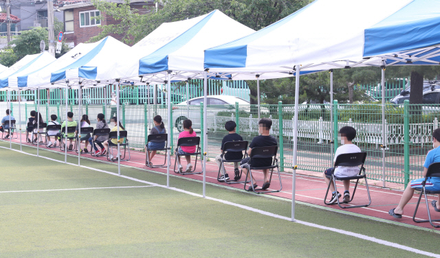 서울 관악구 난우초등학교 학생들이 지난 28일 오전 학교 운동장에 설치된 이동 선별진료소에서 거리두기를 준수하며 코로나19 검사를 받기 위해 대기하고 있다./사진제공=관악구