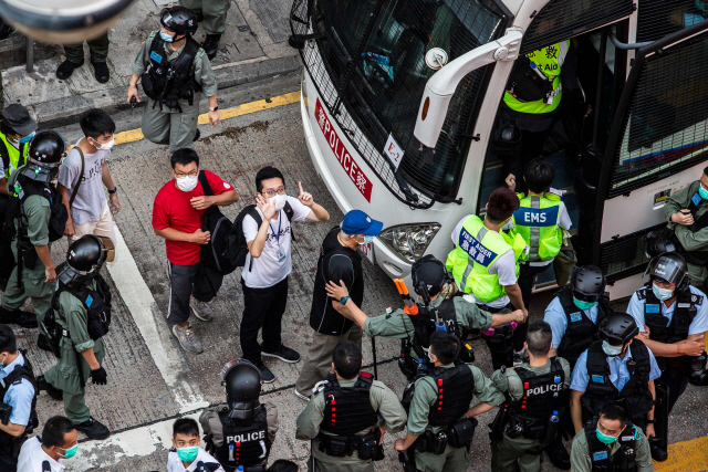 중국 전인대 상무위원회가 30일 홍콩 내 반(反)중국 행위를 처벌하는 홍콩 국가보안법을 제정할 것으로 전망되는 가운데 28일(현지시간) 한 홍콩 시민이 시위 도중 경찰에 연행되며 ‘5대 요구, 하나도 빼놓을 수 없다’는 의미로 손가락을 펼쳐 보이고 있다. 5대 요구는 송환법 공식 철회, 경찰 강경진압에 대한 독립 조사, 시위대의 폭도 규정 철회, 시위대의 조건 없는 석방, 홍콩 행정장관 직선제 등이다./AFP연합뉴스