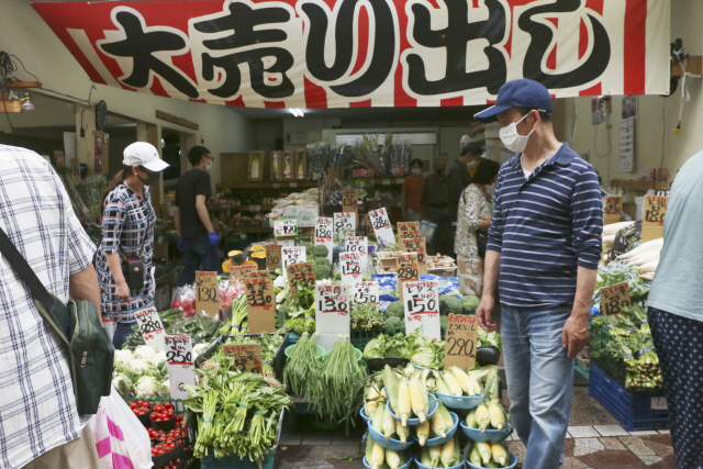 지난달 23일(현지시간) 일본 도쿄 인근 요코하마의 한 시장에서 마스크를 쓴 사람들이 물건을 둘러보고 있다./AP연합뉴스