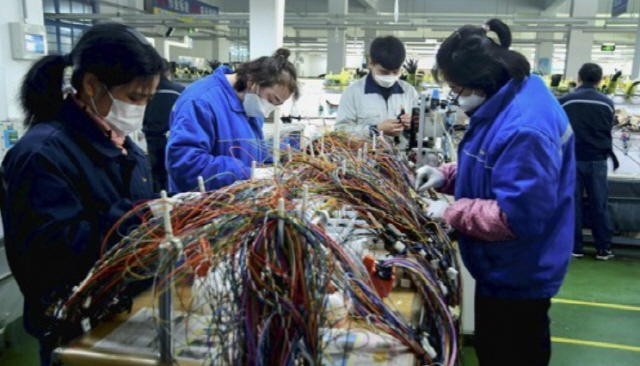 중국 산둥성 칭다오의 한 오토바이 공장에서 노동자들이 일하고 있다. /연합뉴스