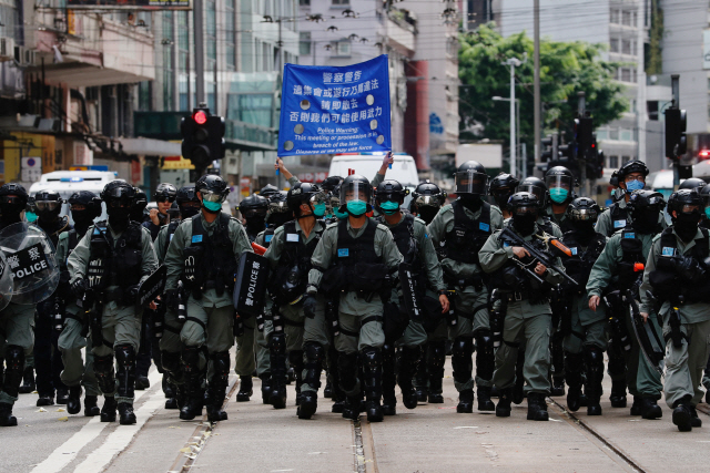 1일 홍콩 경찰이 ‘불법 집회·시위에는 무력을 행사할 수 있다’는 플래카드를 들고 시위진압에 나서고 있다. /로이터연합뉴스