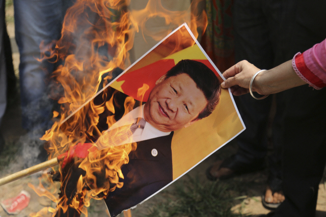 1일 인도에서 한 시위지가 시진핑 중국 국가주석의 사진을 불태우고 있다./AP연합뉴스