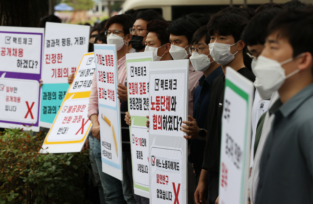 인천국제공항공사 노동조합 조합원들이 지난달 25일 오후 청와대 인근에서 열린 기자회견에서 비정규직 보안검색 요원들의 정규직 전환과 관련한 입장을 발표하며 손팻말을 들고 시위를 벌이고 있다./연합뉴스